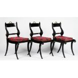 A set of six Regency style ebonised gilt metal mounted dining chairs, with rope-twist bar backs,