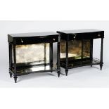 A pair of ebonised bowfronted console tables, in Empire style, with frieze drawers,