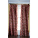 A pair of linen curtains printed with multicoloured designs, with tasseled edging.