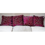 A set of four grey and magenta cut velvet cushions.