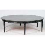 A circular ebonised low centre table, with ceruse finish, on rounded tapering legs, 156cm diameter.