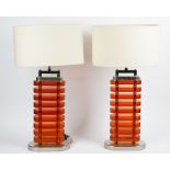A pair of amber perspex and nickel plated table lamps, circa 1960, of oval form, in Art Deco style.