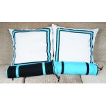A set of four white cushions, with blue and black bands and four corresponding bolsters (8).