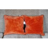 A pair of orange velvet and cable-knit woven fabric cushions (2).