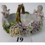 A 19th century `Schneeballen' porcelain basket, modelled with an abundance of flowers, 2 cherubs,