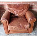 A contemporary tan leather fireside armc