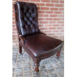 A Victorian mahogany framed library chair upholstered in button backed brown leather and