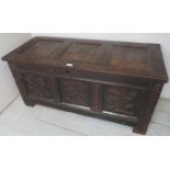 An 18th century carved oak coffer with candlebox panelled top and front and later carving,