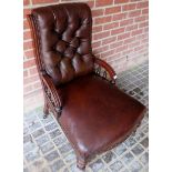 A Victorian mahogany framed armchair upholstered in brown button backed leather,