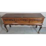 A George III oak dresser base, with three drawers, with later swan handles,