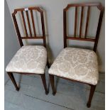 A pair of Edwardian mahogany inlaid bedroom chairs upholstered in cream,