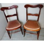 A pair of Edwardian carved bedroom chairs upholstered in a pink velvet material,