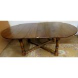 A 20th century oval top refectory dining table with one extra leaf,