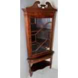 An Edwardian mahogany freestanding corner display cabinet with Astral glazed door and an open base,