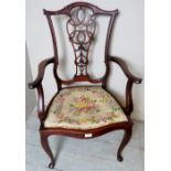 An Art Nouveau mahogany elbow chair upholstered in a needlework material,