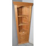 A modern slim pine freestanding corner cupboard,