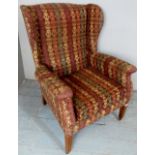 An early-mid 20th century winged back armchair with retro upholstery,