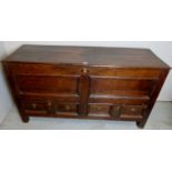 An 18th century oak mule chest, with a planked top over panelled front, with two low drawers,