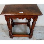 An 18th century oak joint stool, with a carved frieze over turned legs and stretcher,