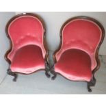 A pair of late Victorian pink upholstered armchairs with mahogany show-wood to arms and legs,