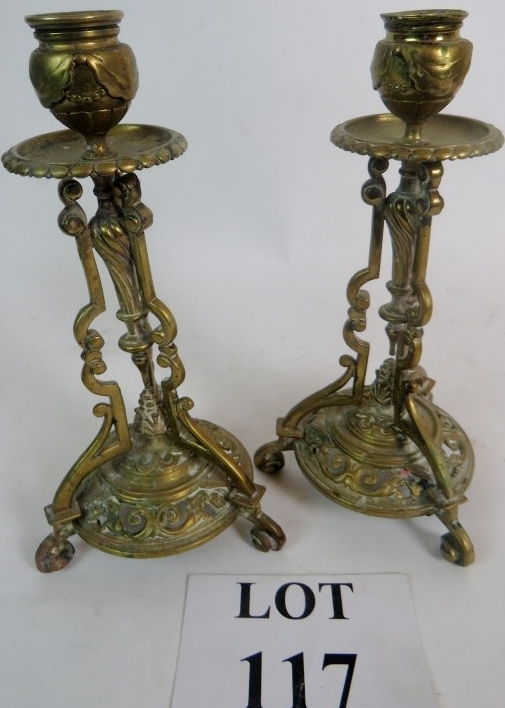 A pair of brass candlesticks of elaborat