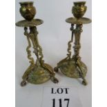 A pair of brass candlesticks of elaborat