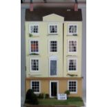 A four storey dolls house in yellow, wit