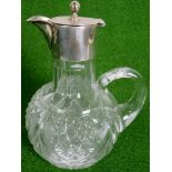 A glass claret jug with silver top, 20cm tall, 12cm diameter at the widest point.