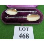 A pair of silver plated spoons, 20cm long, religious themes.