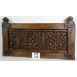 An antique carved wooden panel in the Elizabethan taste, metal mounts, 90cm wide.