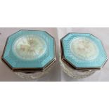 Pair of glass dressing table pots with enamel style and silver floral decorative tops,