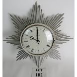 A Junghaus wall clock from the 1960's in silver star burst design, 45cm diameter, ATO-MAT.