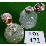 Two scent bottles, one stopper missing, both with cut glass bodies on geometric patterns.