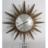 An 18" Metamec clock in teak and brass, made in the 1960's in a sunburst pattern.