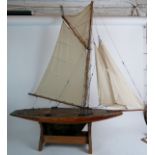 An early 20th century wooden single masted Pond Yacht, shallow hull, deep brass keel,