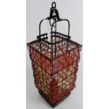 An antique hanging lantern with twisted metal outer frame,