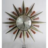 A 24" Metamec clock in teak and brass from the 1960's in a sunburst shape.
