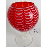 An attractive hand blown glass vase of red and white, lobed pattern over a clear glass stem,