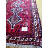 A mid 20th century Shiraz rug, three tier medallion on claret field, 160cm x 110cm approx.