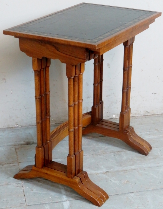 A nest of three 19th Century walnut graduated tables with inset tooled leather tops.