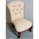 A Victorian mahogany framed low nursing chair upholstered in a cream stripe button backed material.