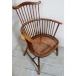 A 19th Century oak framed circular stick back elbow chair with bergere seat.