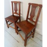 Two Georgian country oak hall chairs with carved back splat's over solid seats and lower stretchers.