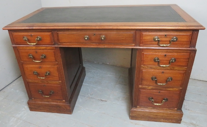 A 19th Century mahogany twin pedestal writing desk with an inset leather top over nine drawers with