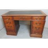 A 19th Century mahogany twin pedestal writing desk with an inset leather top over nine drawers with