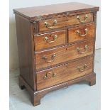 A Georgian design mahogany bachelors chest with a turnover writing area to top over an assortment
