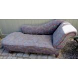 A Victorian mahogany framed chaise lounge upholstered in a floral material on grey/blue ground and