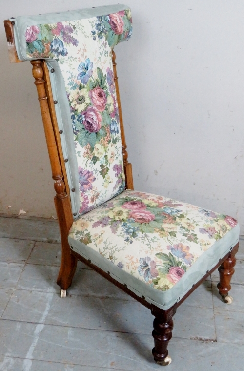 A late Victorian show wood prie dieu prayer chair upholstered in a floral material with turned