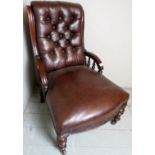 A Victorian mahogany framed armchair upholstered in brown button backed leather,