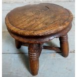 A very small rustic country oak child's milking stool with turned design to legs and cross